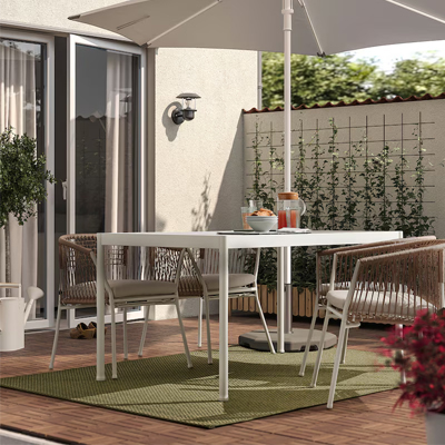 Groen buitenkleed onder een witte tuintafel