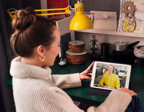 Vrouw heeft thuis een online afspraak met een IKEA specialist.