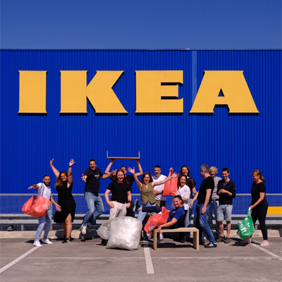 Meerdere mensen voor een IKEA winkel met producten gemaakt van restmaterialen.
