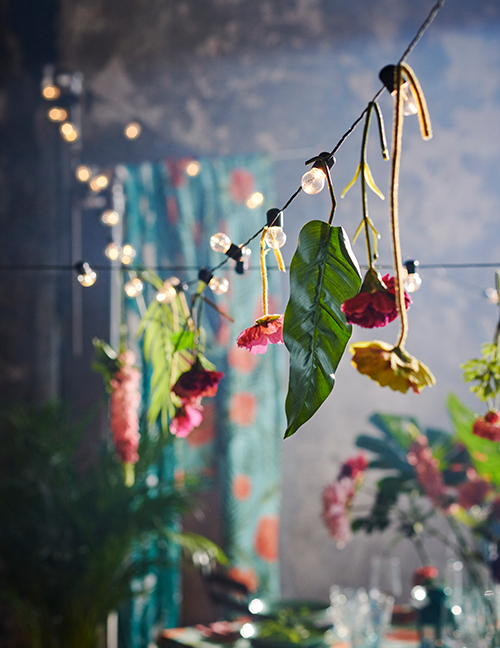 Bloemen en bladeren die aan een lichtsnoer hangen.