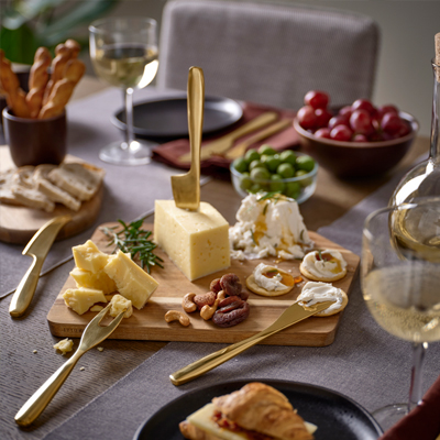 Borrelplank gevuld met crackers, kaas en nootjes.