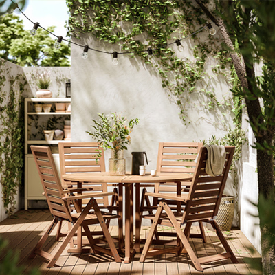 Ronde, houten buitentafel met vier stoelen.