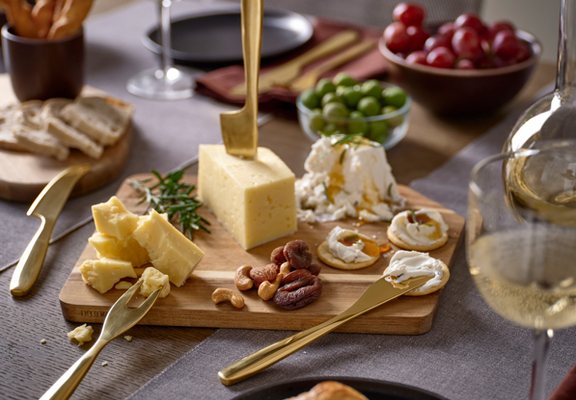 Borrelplank gevuld met crackers, kaas en nootjes.