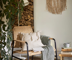 Rieten fauteuil in een ruimte met bijpassende accessoires
