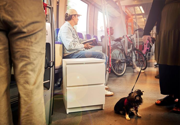 Man zit in de tram met een MALM nachtkastje