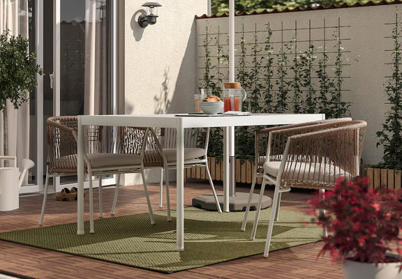 Groen buitenkleed onder een witte tuintafel