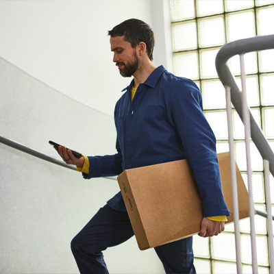 IKEA bezorger loopt de trap op met een pakket in zijn armen