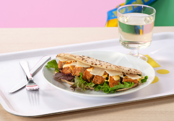 Broodje kip parmezaan met een glas fris.