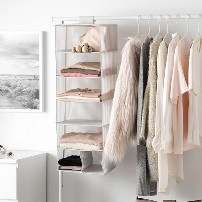 Hangende opberger met 7 vakken, gevuld met kleding en accessoires