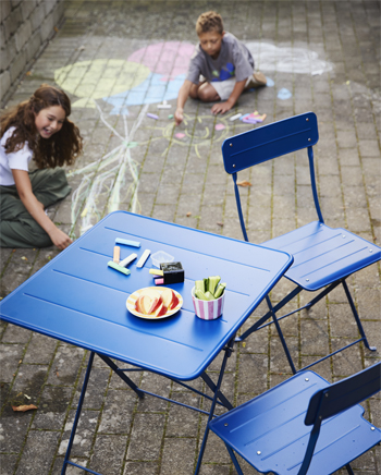 Kinderen krijten achter uitgeklapte tafel en stoelen