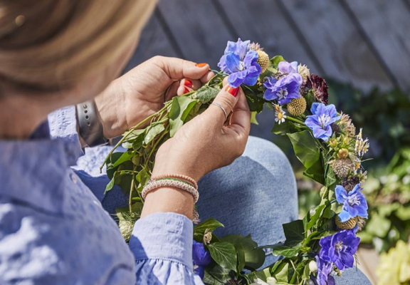 Vrouw maakt een krans van bloemen.