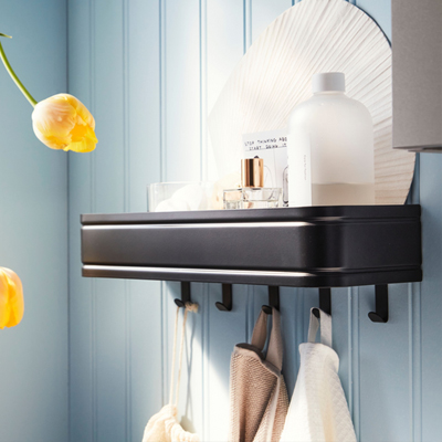 Zwart metalen wandplank in een badkamer, met badjassen en badkamerproducten.