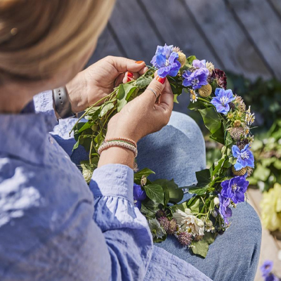 Vrouw maakt een krans van bloemen.
