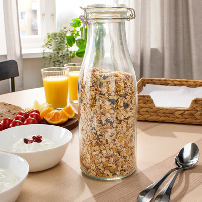 Glazen pot gevuld met muesli op een eettafel.