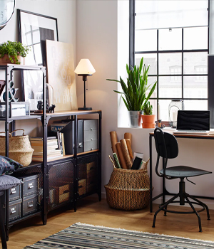 Kamer met zwarte, industriële kast, houten bureau en verschillende planten